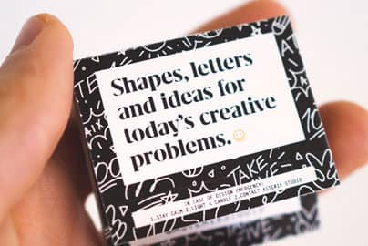 A matchbook being held in someone's hand that reads: Shapes, letters and ideas for today's creative problems.